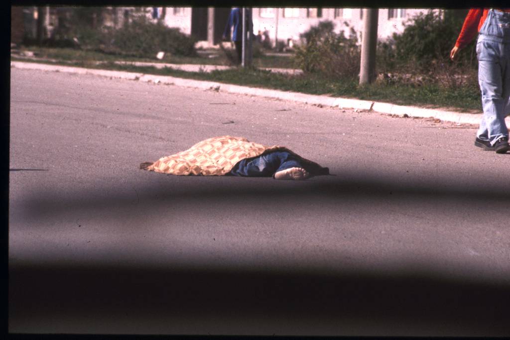 Eine tote Person liegt mit einer Decke abgedeckt auf der Straße.