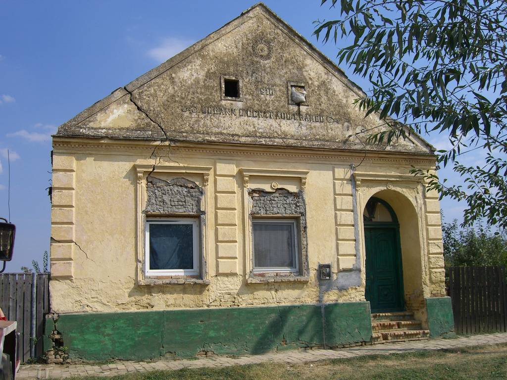 Ansicht der zur Straße zeigenden Fassade eines donauschwäbischen Hauses.