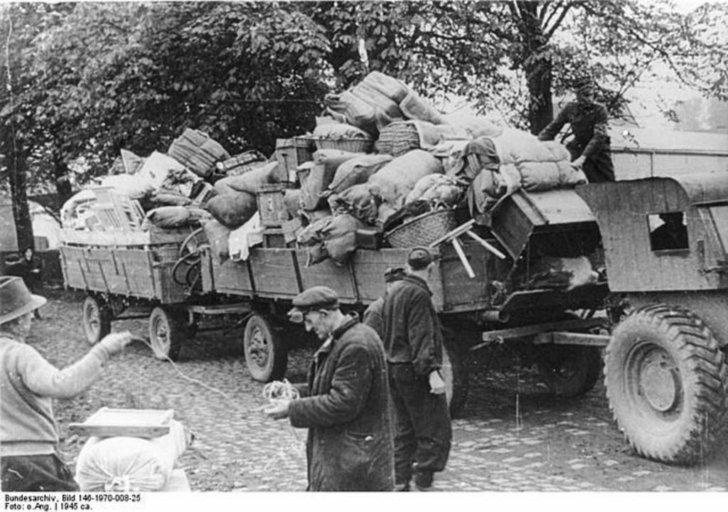 Umsiedlung der Deutschen aus den Polen zugesprochenen Gebieten östlich von Oder und Neiße.- Ein unformierter Pole kontrolliert 2 vollbeladene Anhänger (1945?)